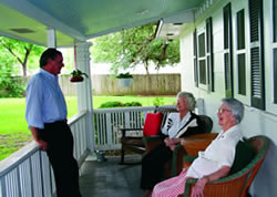 Gouger chats with residents on the porch of his Gonzales home