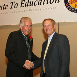 Dr. Agnese shakes hands with Clarence Kahlig, dealer principal of North Park Lincoln Mercury.