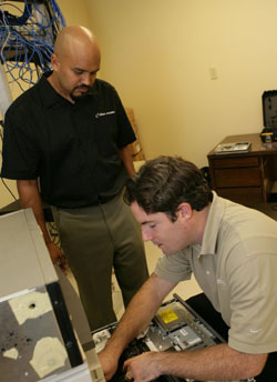 Ali ‘94 and Blankenship ‘02 examine demo hardware setup.